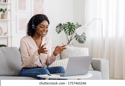 Video Conference. Smiling african woman having web call on laptop at home, talking at camera while sitting on sofa in living room - Shutterstock ID 1757465246
