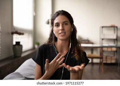 Video conversation. Inspired latin female teacher in headphones meet students online look at camera give virtual class. Portrait of confident young saleswoman wear headset consult client by videocall