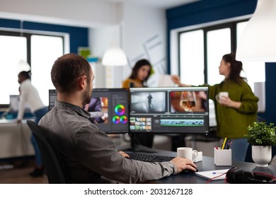 Video editor cuting footage working at film editing montage on computer with dual monitors setup in multimedia creative agency office. Videographer man processing film using post production software - Powered by Shutterstock