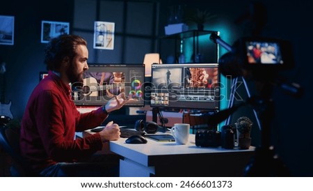 Video editor filming online tutorial about editing color grading and lighting. Post production expert in home studio recording guide for internet audience about working with raw footage