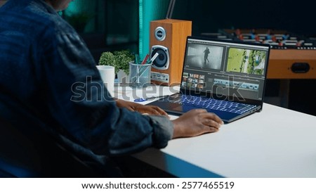 Video editor selecting key frames to use while doing video montage, working from home on notebook device. Woman using mouse to edit movie project footage in apartment office, camera A