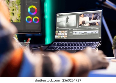 Video editor working on creative software to create a film montage, using color correction wheel and adding visual effects. Male creator editing gradient for movie post production, white balance.