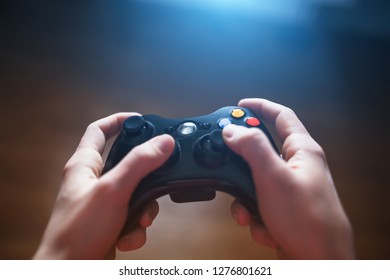 Video game controller in human hands, in front of the TV