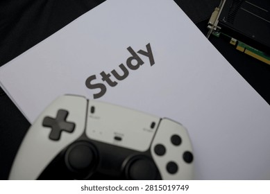 A video game controller rests on top of study materials in a casual study space.
