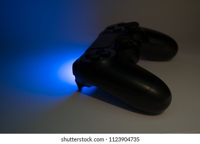 Video game controller in shadow with blue light emitting