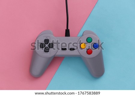 Video game Gamepad. Gaming concept. Top view retro joystick on pink blue pastel background.