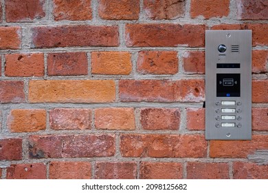 Video Intercom On Red Brick Wall Background. Modern, Luxury, Wealthy Home Security System. Alarm Door Bell. Safe Entrance To The Apartment. Smart Home Technology, Street View. Close Up, Copy Space