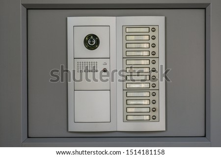 Video intercom system on grey background at residential or office building. 