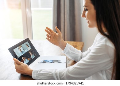 Video Meeting. A Woman In Formal White Shirt Is Using A Digital Tablet For Video Connection, Video Call In The Office. Online Conference With Several People Together