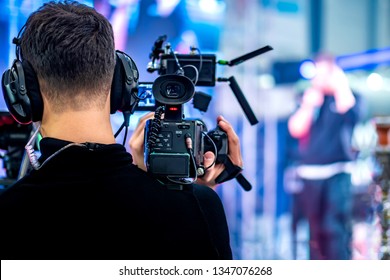 Video operator shoots on camera. Video camera with a transmitting device over Wi-Fi. Video production. Videographer in headphones. Video stream