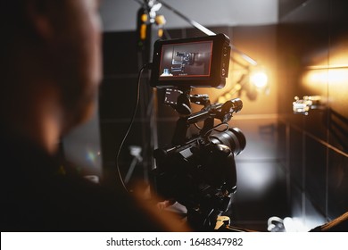 Video production backstage. Behind the scenes of creating video content, a professional team of cameramen with a director filming commercial ads. Video content creation, video creation industry. Low