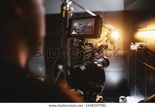 Video production backstage. Behind the scenes of\
creating video content, a professional team of cameramen with a\
director filming commercial ads. Video content creation, video\
creation industry. Low