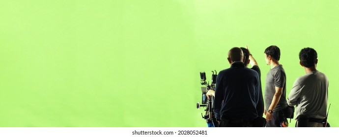 Video production behind the scenes. Making of TV commercial movie that film crew team lightman and cameraman working together with film director in studio. film production concept. Silhouette style. - Shutterstock ID 2028052481