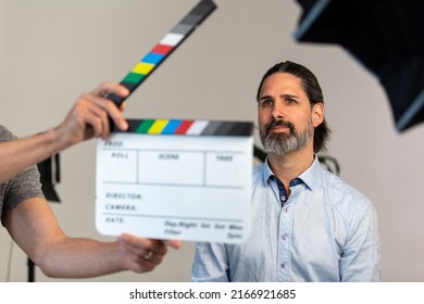 Video Production Movie Slate Being Using In Front Of Business Man On Film Set. Focus Is Adult Male