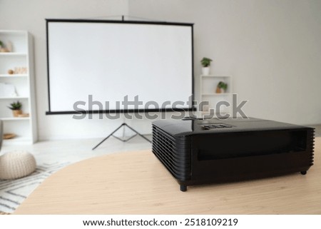 Video projector on dining table in light room, closeup