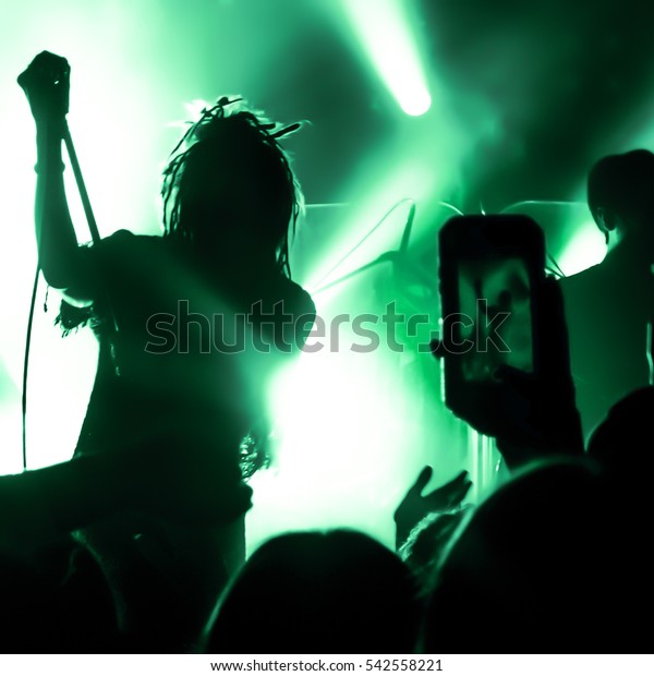 Video recording of the concert on the phone a\
smartphone. Reggae\
colors.