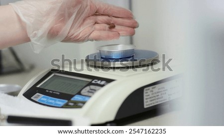 A video shows precise weighing of objects on a scale