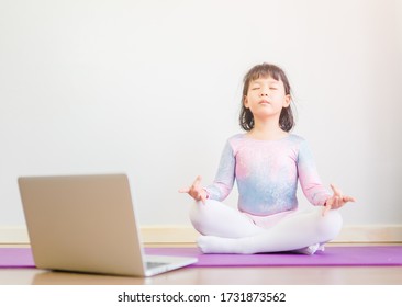 Video streaming Stay fit at home.home fitness workout class live streaming online.Asian kid girl in yoga gymnastics keep calm and fit.Online class live videos on laptop at home.New normal healthcare. - Powered by Shutterstock