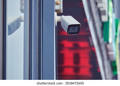 Video Surveillance Camera On The Store Building, Monitoring The Security Of The Entrance To The Shopping Center