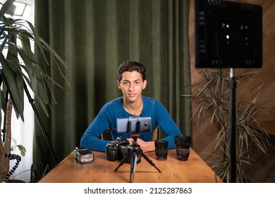 Video training for beginner photographers, online courses. A Muslim man records a video review of photographic equipment using an application on a smartphone. The structure of the camera and lens.