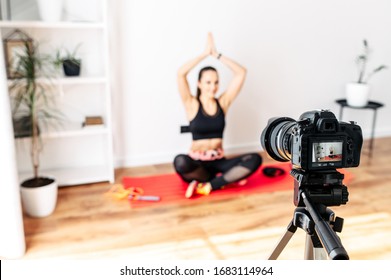 Video training, online master class. The image of a girl on the camera screen, she practices yoga and records herself on video - Powered by Shutterstock