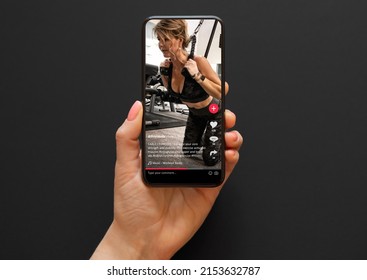 Video with a woman working out in a gym shared on social media app viewed on a mobile phone