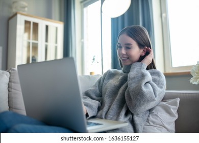 Videochat. Young Girl In A Grey Sweater Having A Videochat