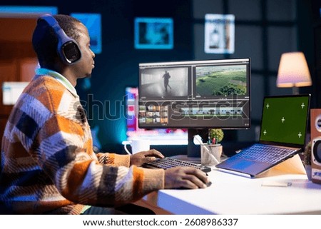 Videographer creating visual effects on montage next to green screen, working on color correction to edit footage and frames. Freelancer content creator editing clips on computer software.