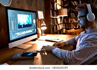 Videographer editor film maker wears headphones using digital software on desktop computer editing video footage visual content working at home office using post production multimedia making montage.