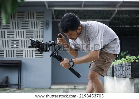 Videographer filmmaker cinematographer dop with gimbal and dslr camera. Filmmaking, videography, hobby and creativity concept.