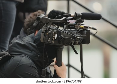 Videographer Holding Video Camera With Microphone