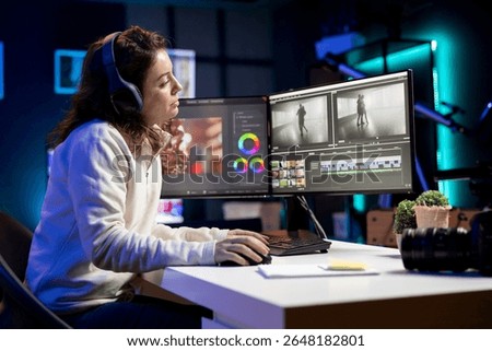 Videographer uses software to create visual effects for video projects while relaxing with some music. Professional wearing headphones using post production techniques to edit raw footage