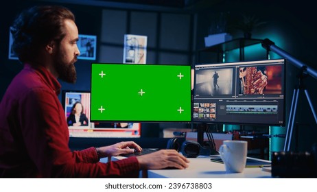 Videographer using professional software on mockup PC to create visual effects for video projects. Expert using post production techniques to edit raw clips footage on green screen computer