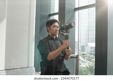 Videographer or Video Camera Operator taking shots indoors. Film Production and Stock Footage. Hobby and creativity concept. - Shutterstock ID 2344570177