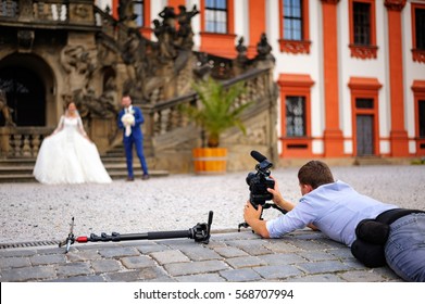 Videographer working at a wedding while lying on the floor