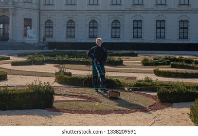 Vienna, Austria - 02/15/2019 Girl Cutting Grass In Belvedere Park