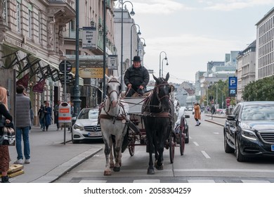 Vienna, Austria - 10.11.2021: Horse Carriage Riding In The Vienna City Center. Fancy Looking Gentelman Driving A Horse Wagon In The Austrian Streets. Two Horses In Front Of A Turist Wagon. 