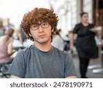 Vienna, Austria, August 18, 2022. In a cafe in the old town portrait of a nice caucasian boy looking at the camera. Positivity and self-confidence.