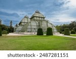 Vienna, Austria, August 20, 2022. In the gardens of Schönbrunn Palace, the historic greenhouse stands out for its characteristic design. Travel destinations. Copy space.