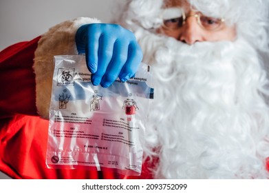 VIENNA, AUSTRIA - DECEMBER 10, 2021: Santa Claus Holding Biohazard Bag With PCR Gargle Test
