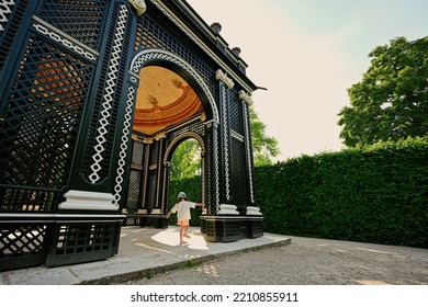 Vienna, Austria - May 17, 2022: Baby Girl Under Wooden Arbor Arch At Schonbrunn Palace In Vienna, Austria.