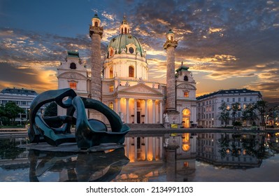 Vienna, Austria - May 7th 2019: Panorama of the St. Charles Church (Karlskirche) in Vienna with sculpture and fountain during a sunset with clouds