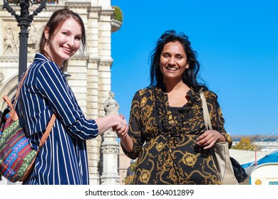 VIENNA, AUSTRIA - OCTOBER 6th, 2018: Two Girls Of Different Cultures Communicating On The Street. Concept: Intercultural Communication