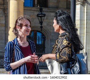 VIENNA, AUSTRIA - OCTOBER 6th, 2018: Two Girls Of Different Cultures Communicating On The Street. Concept: Intercultural Communication