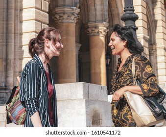 VIENNA, AUSTRIA - OCTOBER 6th, 2018: Two Girls Of Different Cultures Communicating On The Street. Concept: Intercultural Communication