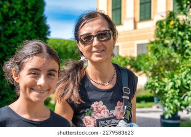 Vienna family tourism. A young girl with her mother visiting Schonbrunn Park.