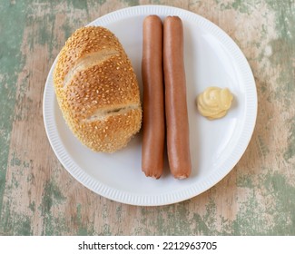 Vienna Sausage With Mustard And Sesame Seed Bun On A Plate Isolated On Wooden Background