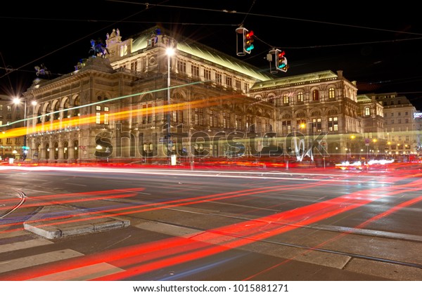 Vienna State Opera at night with car light trails\
on the Vienna Ring\
street.