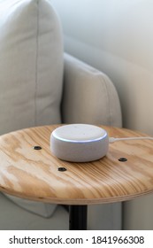 VIENNA,AUSTRIA - October 26 : A white Amazon Alexa Echo on a small wooden side table with a white sofa in the background