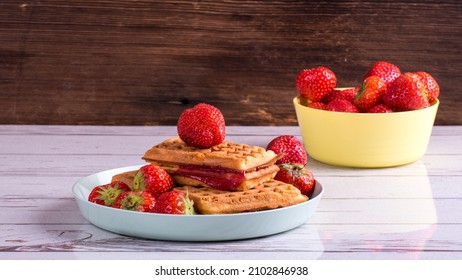 Viennese waffle muffins with strawberries and jam on a plate, top view, copy space, healthy breakfast